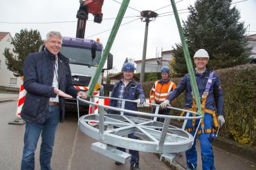 Veit Meggle und Arbeiter neben an Kran hängendem Metallkorb