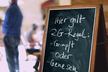 Tafel mit Kreide beschrieben: Hier gilt 2G-Regel: Geimpft oder Genesen