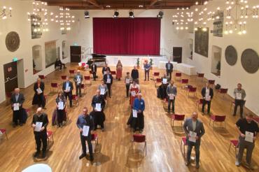 Menschen mit Urkunden stehen in Stadtsaal Klösterle