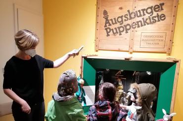 Im Bild zu sehen: Kristina Wnuk, zuständig für Museumspädagogik und Führungen für Kinder, mit den kreativ Kids im Puppenmuseum. 