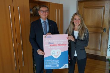 Landrat Stefan Rößle und Konversionsmanagerin Barbara Wunder bei der Vorstellung des Aktionsplakates „Pass mer zam?“ zur Pop-up-Store Initiative. 