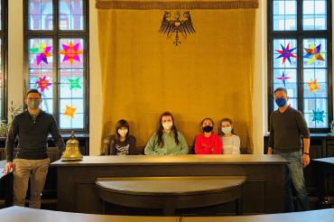 Die kleinen Künstlerinnen vom Hort an der Hans-Schäufelin-Schule haben ihre Sterne im Sitzungssaal im Rathaus selbst aufgehängt (v.l.: Oberbürgermeister David Wittner, Svenja, Lisa, Beren, Elena, Martin Wiedemann (Leiter Hort an der Hans-Schäufelin-Schule)).
