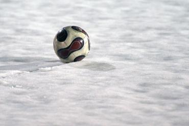 Auf dem Bild sieht man einen Ball im Schnee.