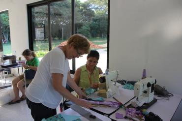 Auf dem Bild sieht man eine Frau an einer Nähmaschine.