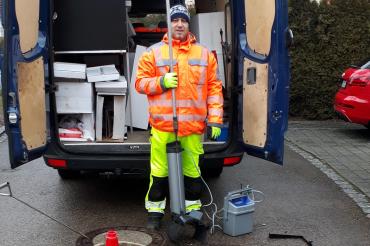 Ein Mitarbeiter der Firma Anticimex bringt eine Falle zur Rattenbekämpfung in einen Kanal ein. 