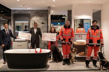 Das Bild von der Spendenübergabe in der neuen Bäderausstellung in Nördlingen zeigt von links Oberbürgermeister David Wittner mit dem Scheck für die Stiftung „Nördlinger Hilfe in Not“, Eisen-Fischer-Geschäftsführer Volker Baumgärtner sowie von der Rettungshundestaffel Ries Ausbilderin Patricia Schlosser, den 2. Vorsitzenden und Gruppenführer Marcel Neubauer und Hundeführer Fabian Altmann, jeweils mit ihren Rettungshunden Lotte, Max und Emma.  