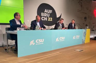 Das Bild zeigt Ulrich Lange, Friedrich Merz, Markus Söder und Alexander Dobrindt am Podium