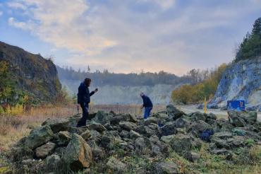 Auf dem Bild sieht man zwei Menschen auf Steinen.