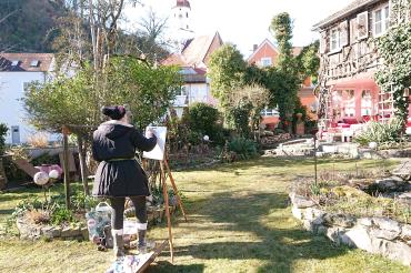 Frau malt in einem Garten in Harburg