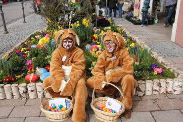 Auf dem Bild sind zwei Menschen verkleidet als Osterhasen zu erkennen.
