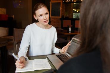 Eine Frau berät eine weitere Person.