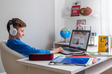 Junge nimmt mit Laptop an Online-Kurs teil