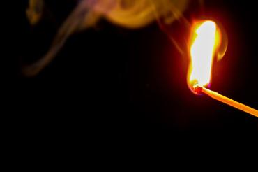 Das Bild zeigt ein entzundenes Streichholz