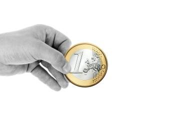 Eine Hand die eine Euromünze hält.