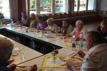 Das Bild zeigt Senioren beim Mittagessen.