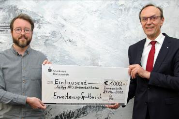 Das Bild zeigt Achim Zinsmeister und Sparkassendirektor Johann Natzer bei der Scheckübergabe.