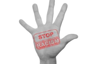 Zu sehen ist eine Hand mit der Aufschrift "Stop Racism"