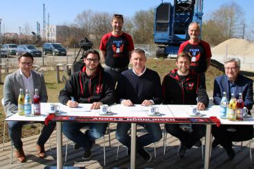 Ajtony Imreh, Angels-Verantwortliche und Eigner-Geschäftsführung sitzen bei Vertragsunterzeichnung an Tisch