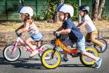 Kinder mit Helm fahren Lauf-Fahrräder