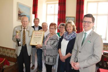 Zu sehen ist ein Gruppenfoto bei der Übergabe der Urkunde an Hans Irrgang. 