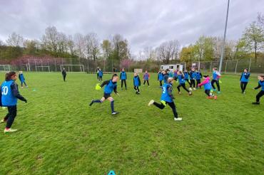 Zu sehen sind eine Gruppe Mädchen während einem Fußballspiel. 