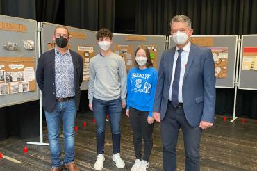 Zu sehen sind Ulrich Fritz, Luis Stegmüller, Frau Julia Förg und Markus Edenhofer vor Ausstellungstafeln. 