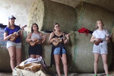 Vier junge Frauen mit Ukulele vor Heuballen