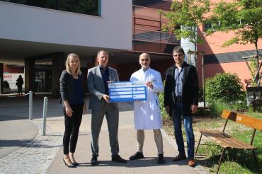 Zu sehen sind Mareike Baumann, Jürgen Neumann, Dr. Thomas Klaus Schmitt und Helmut Gerstmeier bei der Spendenübergabe vor dem Stiftungskrankenhaus. 