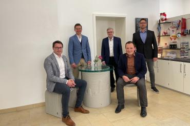 Fünf Personen auf Betonsitzgruppe. 