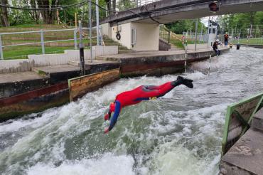 Zu sehen ist eine Person, die in einen Kanal springt. 