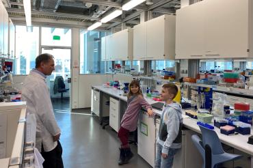 Auf dem Bild sind Prof. Paul Pfluger, Alessandra und Henry im Labor des IDO zu sehen.