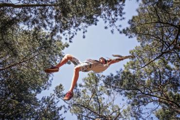 Das Bild zeigt ein Kind an einem Seil.