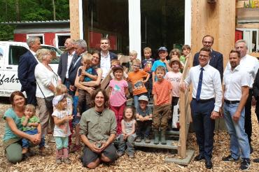 Zu sehen sind Erwachsene und Kinder vor dem Waldkindergarten an der Alten Bürg. 
