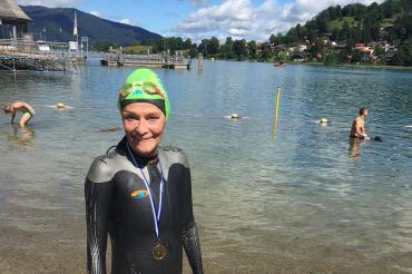 Claudia Koch mit Medaille vor dem Tegernsee. 