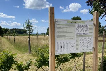 Infoschild vor Obstgarten. 