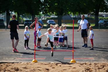 Kinder beim Hoch-Weitsprung. 