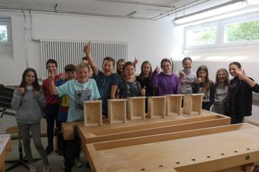 Das Bild zeigt die Klasse 6A vor ihren gebastelten Nistkästen.