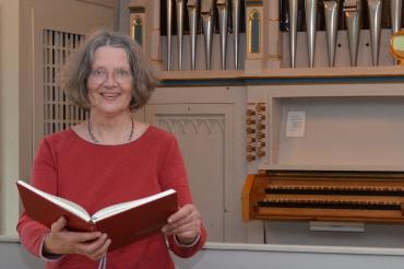frau, stehend, mit Gesangsbuch in der Hand