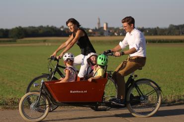 Das Bild zeigt eine Familie beim Radfahren.