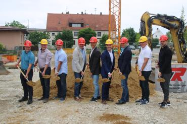Auf dem Bild zu sehen beim Spatenstich für das Gebäude am Marktplatz Nord in Asbach-Bäumenheim (von links): Otto Uhl (Gemeinderat), Stefan Reicherzer (Gemeinderat), Lars Meier (Gemeinderat), Hansrobert Schimmer (Gemeinderat), Stefan Bissinger (Leitung Bauamt), Ulrich Reitenberger (Geschäftsführer Ulrich Reitenberger Bau GmbH), Martin Paninka (Bürgermeister), Georg Feistle (Projektleiter) und Maurice Wiedenmann (Projektentwicklung).