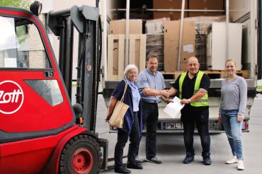 Nach der erfolgreichen Verladung der Spenden übergibt Albert Reiner (2. v.l.), zweiter Bürgermeister der Gemeinde Mertingen die Frachtpapiere. Stellvertretend für die Helferinnen und Helfer waren Gemeinderätin Ulrike Hampp-Weigand (1.v.l) aus Mertingen und Dominika Fellner (1.v.r), Zott Unternehmenskommunikation, bei der Übergabe anwesend. 