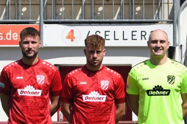 acht Männer in Fußballtrikos