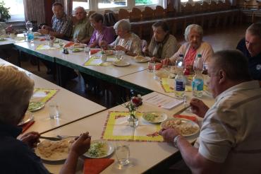Zu sehen sind mehrere Senioren beim Mittagessen. 