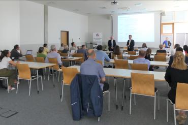 Zu sehen sind mehrere Personen bei einem Vortrag. 