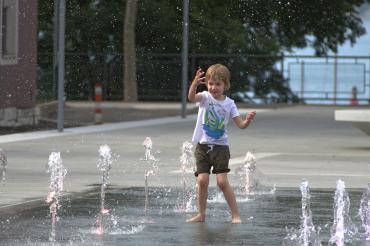 Kind spielt an Bodensprudelanlage/Wasserspiel