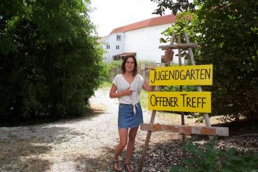 Das Bild zeigt Jugendsozialarbeiterin Nina Thorwart im Jugendgarten vor dem Löpsinger Tor.