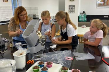 Lilia Lamparter beim Backen zusammen mit Kindern.