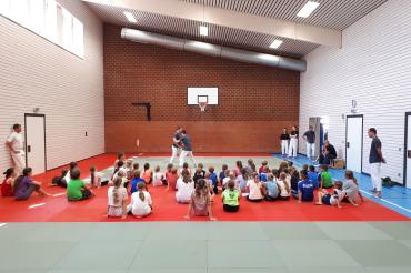 Das Bild zeigt die Betreuer*innen und die Kinder des Ferienprogrammes in der Turnhalle in Kleinerdlingen.