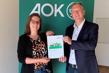 AOK Direktor Michael Meyer übergibt den Gesundheitsbericht an Julia Lux, Geschäftsstellenleitung der Gesundheitsregion plus Donau-Ries.