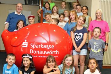 Das Bild zeigt die Feriengäste mit (links) Didi (Thomas Deuter) und (rechts) Dodo (Carolin Fürst) vom KNAX-Klub der Sparkasse Donauwörth, die das Programm gestalteten.